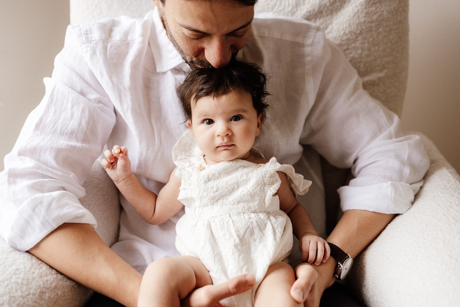 A dad kisses his baby's head at their in-home newborn session in Los Gatos, CA