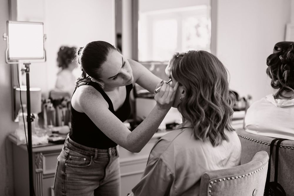Black and white photo showing preparations in a bright room with natural window light.