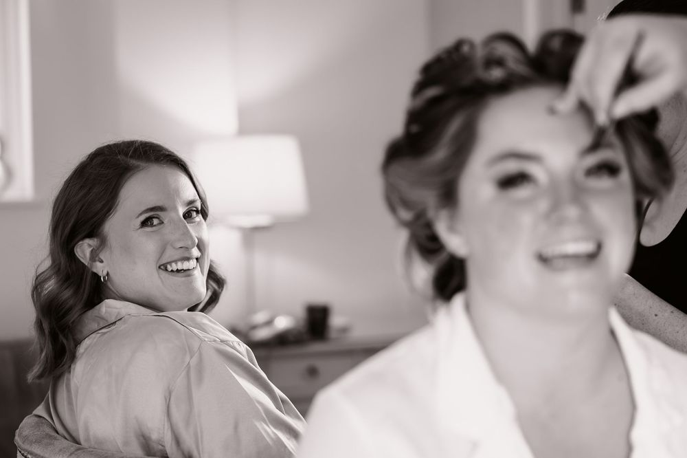 Black and white photographs capturing joyful moments during wedding preparation.