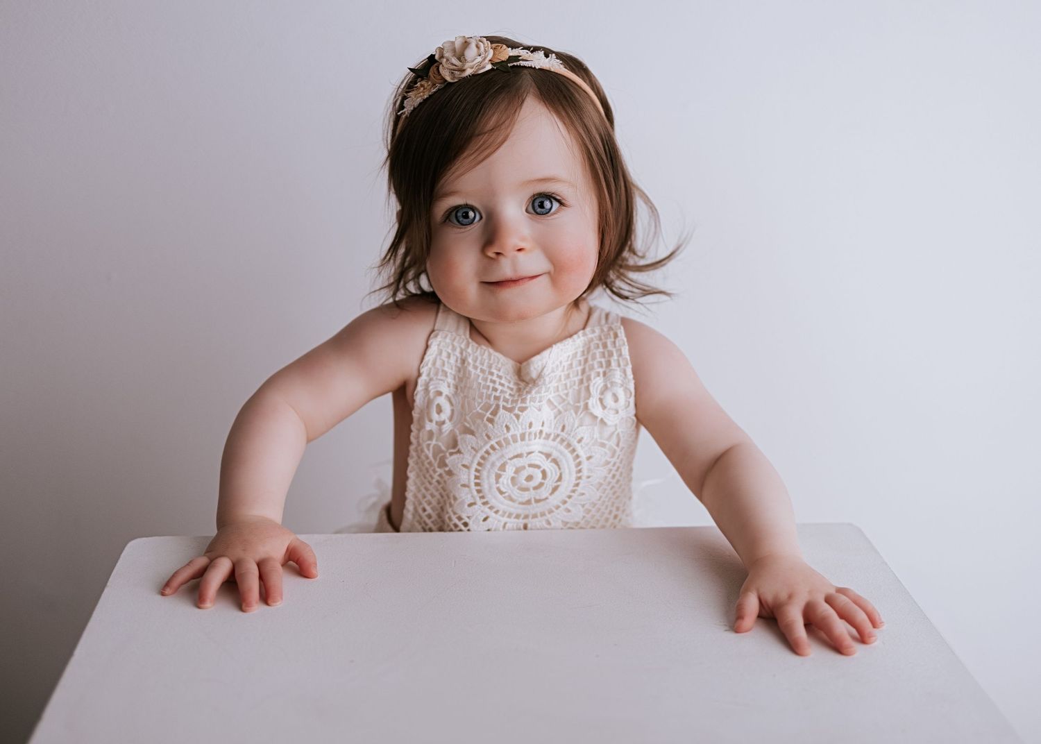 A series of connected photos showing a baby in a white high chair against a neutral gray background.