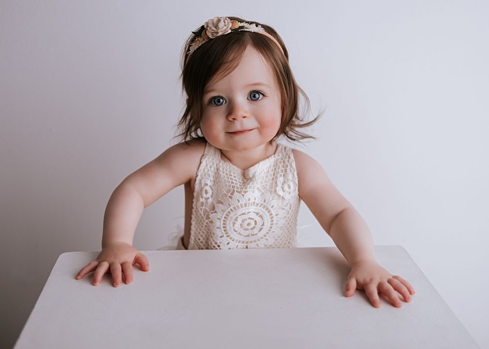 A series of connected photos showing a baby in a white high chair against a neutral gray background.