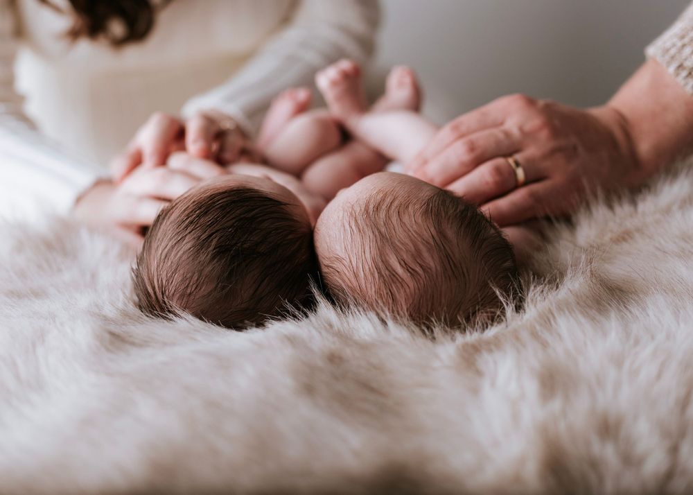 Close-up shots of a newborn baby lying on soft white fur blanket.