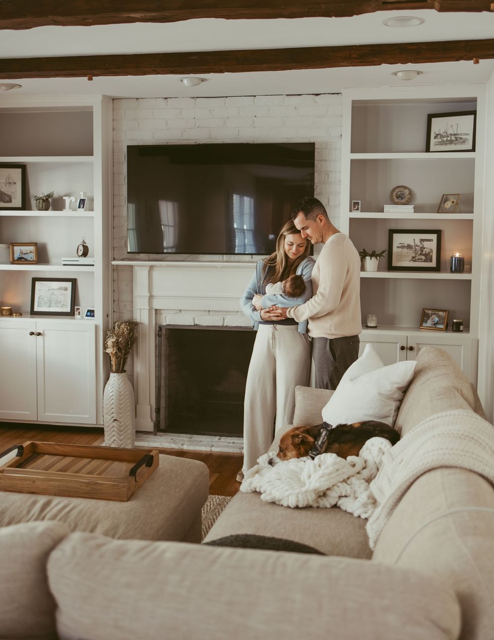Cozy living room interior with built-in shelving, fireplace, and comfortable grey couch with decorative throw pillows.