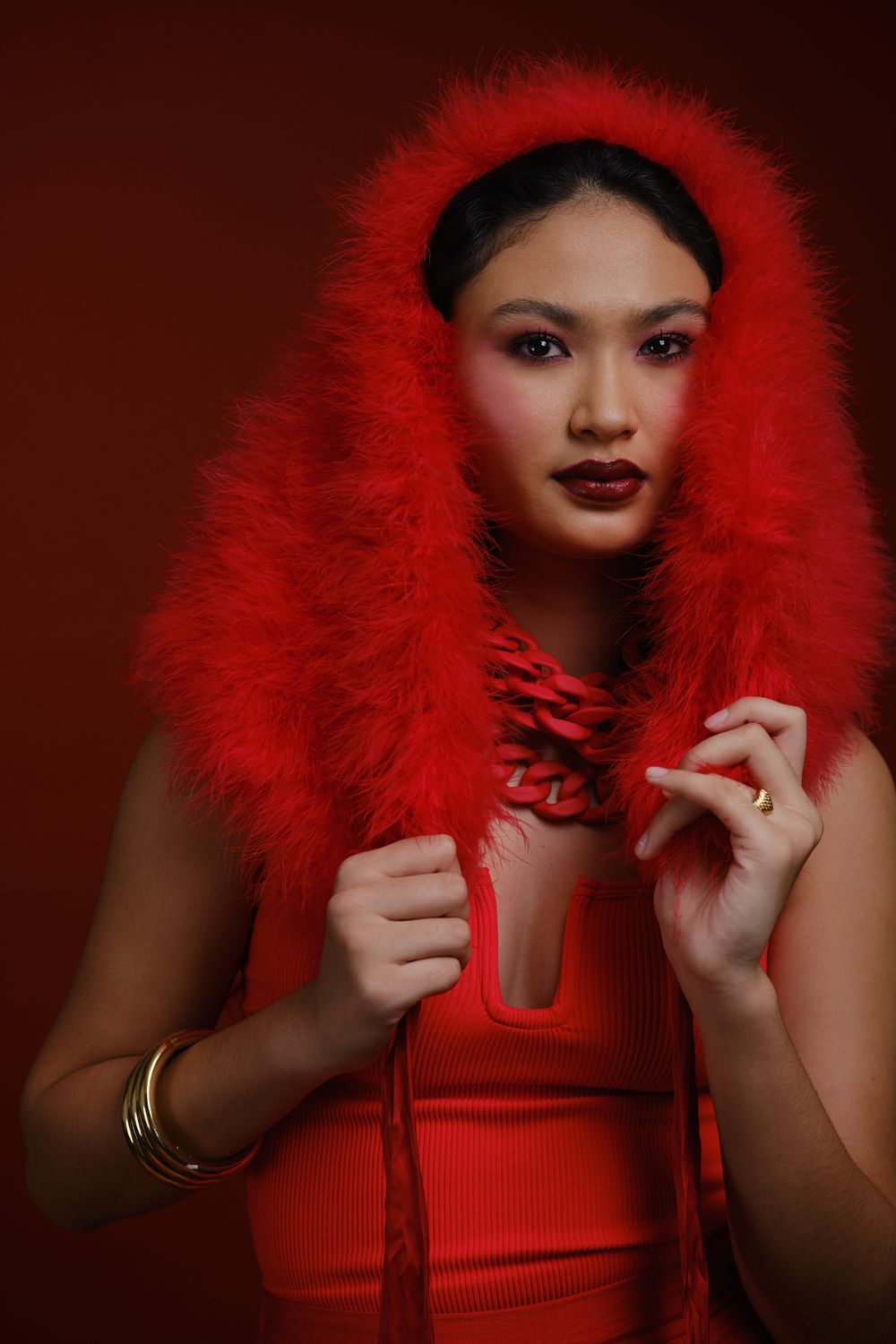 Portrait de Hiilei, modèle de la Tahiti Fashion Week, sur un fond rouge en studio.
