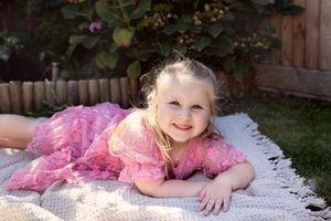 Joyful outdoor family photo session with bubbles and laughter on a white blanket.