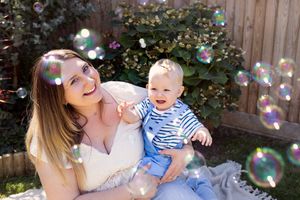 Playful family moment with soap bubbles during outdoor photography session.