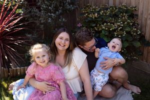Outdoor family portraits captured in a backyard setting with natural lighting and greenery.