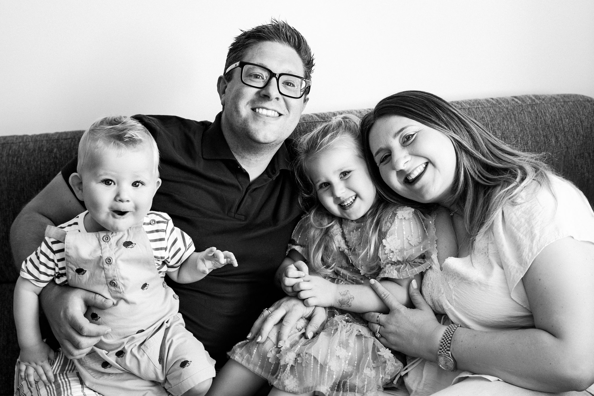 A series of black and white family photographs showing candid moments of parents and children relaxing together.