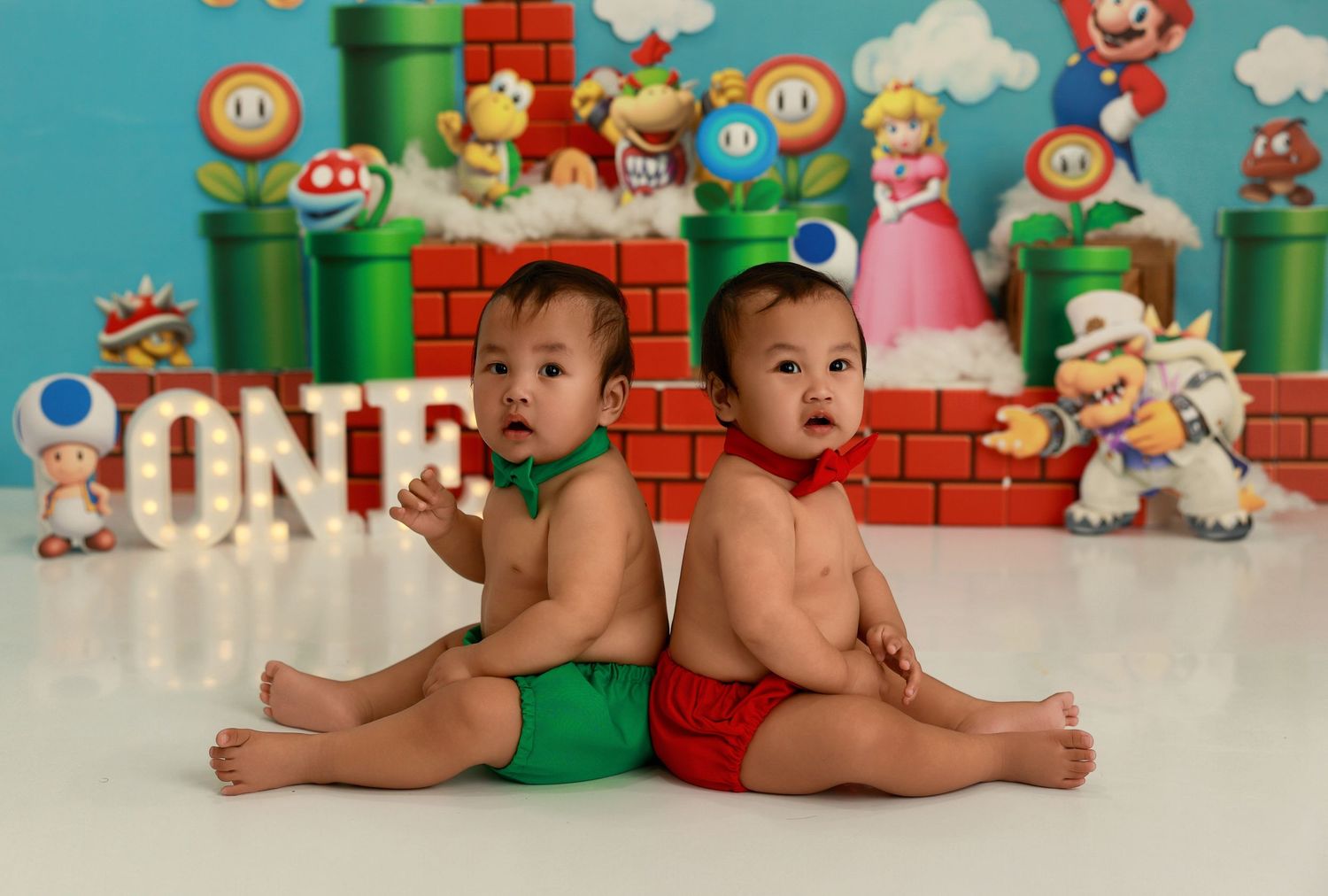 Super Mario themed baby portrait with retro gaming decorations, green pipes, and mint colored cakes.