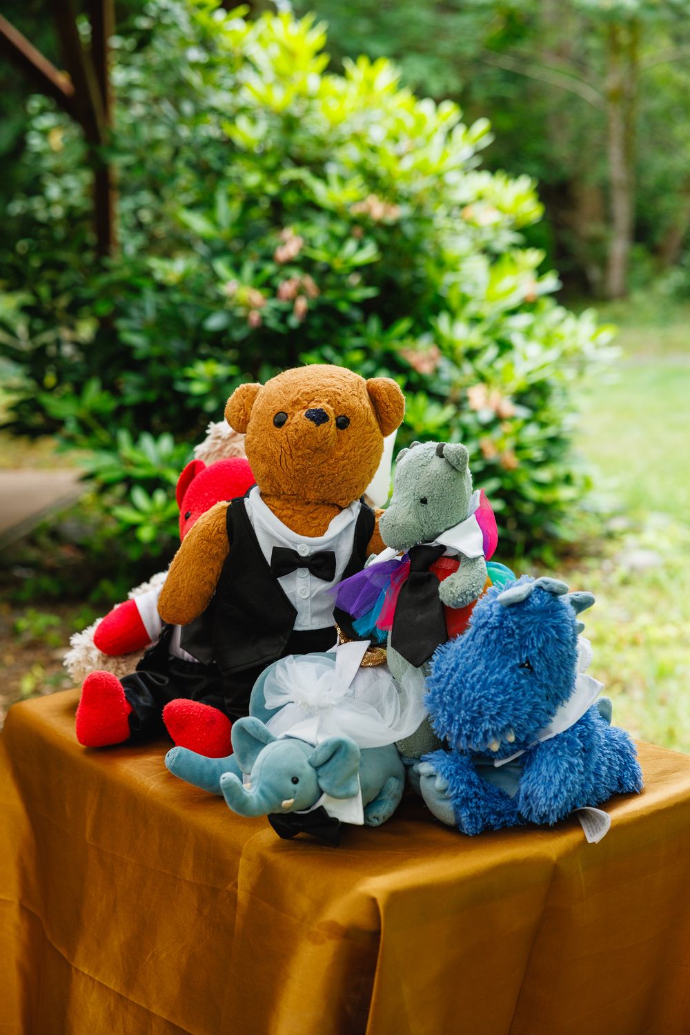 Adorable stuffed animal wedding display featuring teddy bears dressed as bride and groom outdoors.