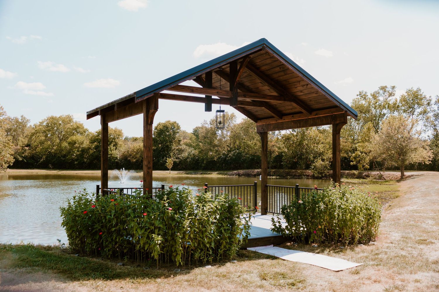 Covered deck sitting next to a lake, surrounded by wildflowers for an intimate, summer backyard wedding in Hamilton, Ohio