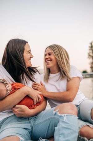 Two friends sharing joyful laughter while sitting together outdoors.