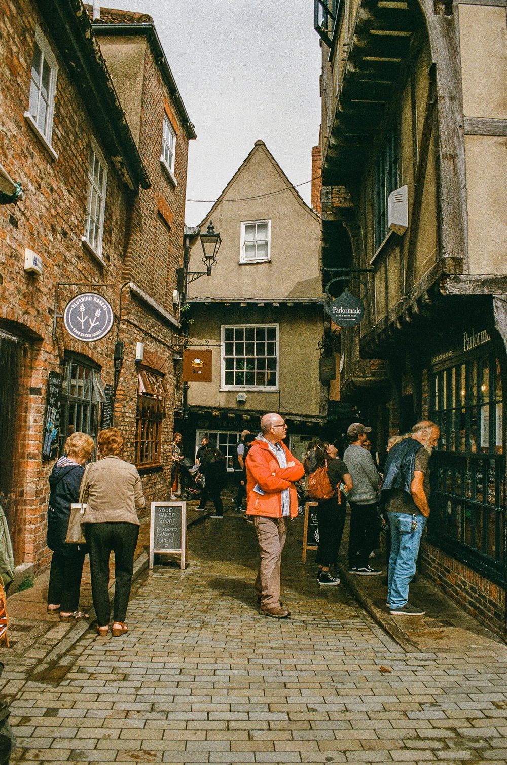 Tourists exploring The Shambles, a historic medieval street in York with timber-framed buildings.