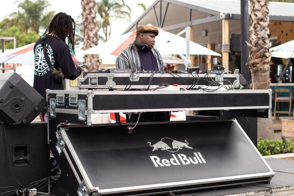 DJ equipment setup with Red Bull branding at an outdoor poolside event.