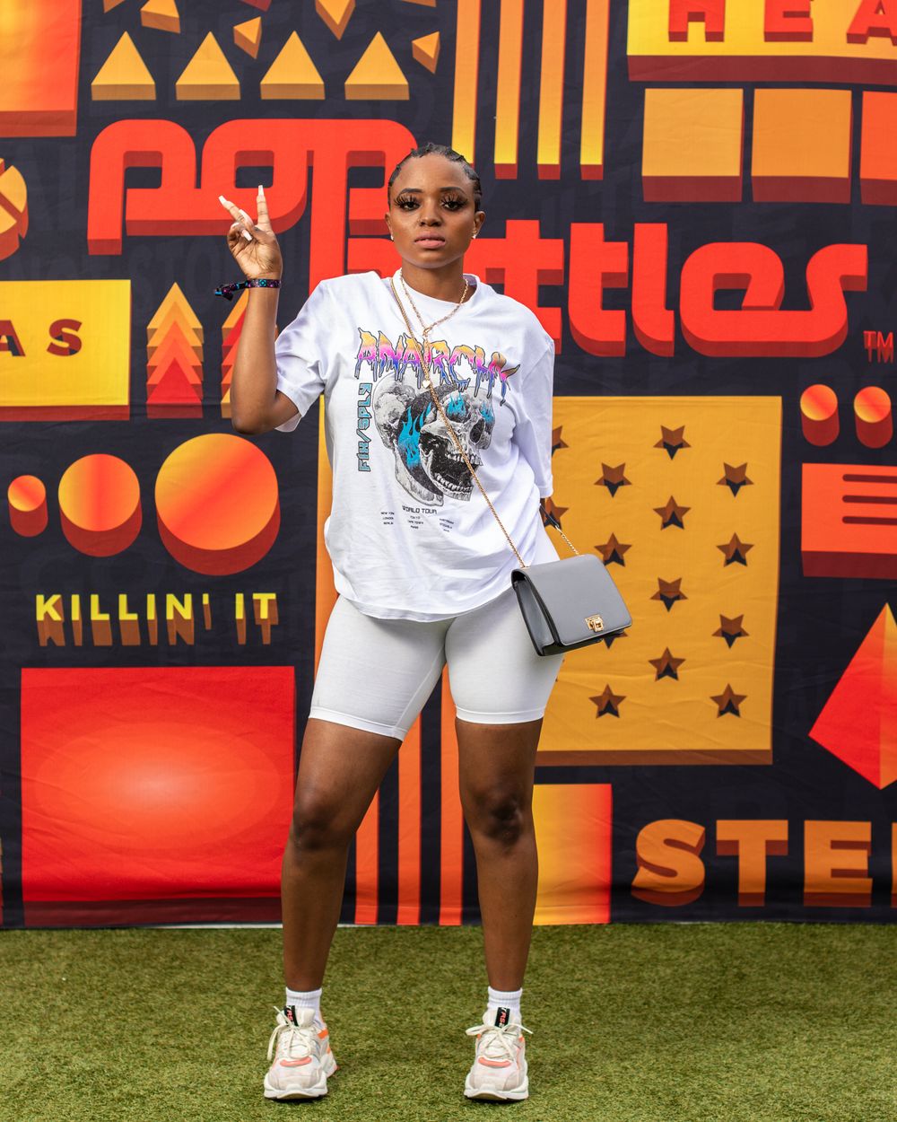 Athletic streetwear look with graphic tee and bike shorts against colorful urban wall display.
