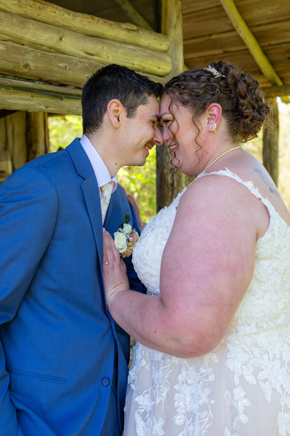 A romantic moment shared between newlyweds in formal wedding attire under a wooden gazebo on their special day.