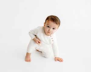 Photo of little boy in a white romper by 2nd birthday photographer in Menifee.