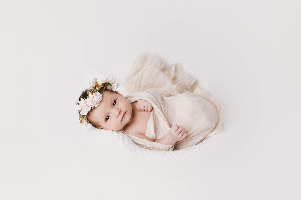 Cute baby girl looking at camera by affordable newborn photographer in Murrieta.