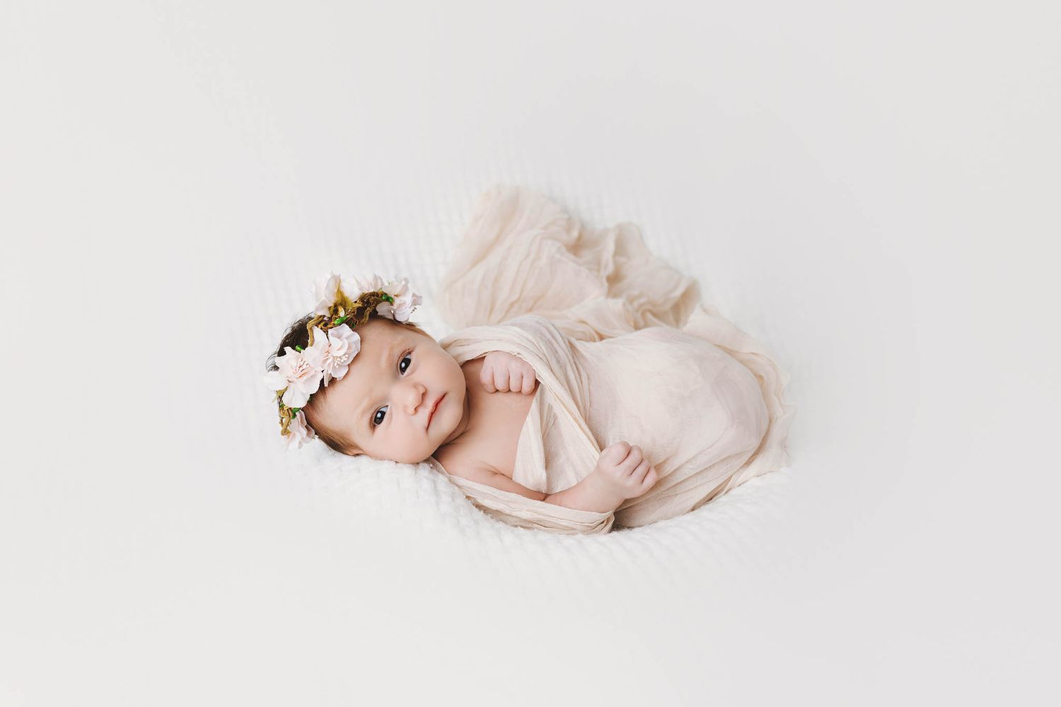 Cute baby girl looking at camera by affordable newborn photographer in Murrieta.