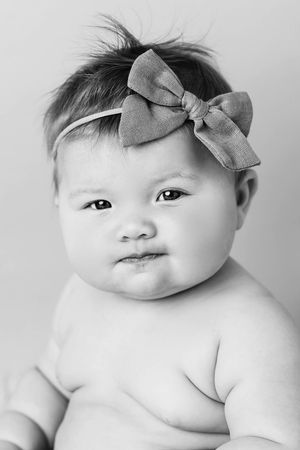 Black and white portrait of a chubby baby girl in 6 month photoshoot.