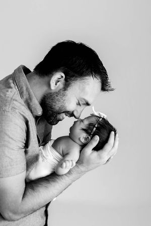 Menifee newborn and family photographer black and white photo of dad holding newborn baby girl.