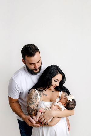 Family's first photo with parents holding newborn baby girl.
