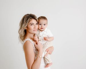Mom holding baby boy for first birthday photoshoot by professional infant photographer in Menifee.