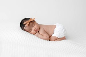Newborn photoshoot of sleeping baby girl.