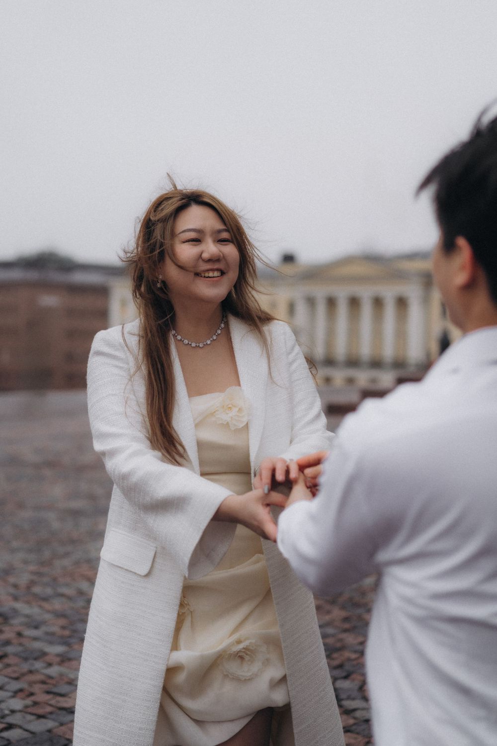 Bride-to-be laughing during a playful engagement session at Senate Square in Helsinki