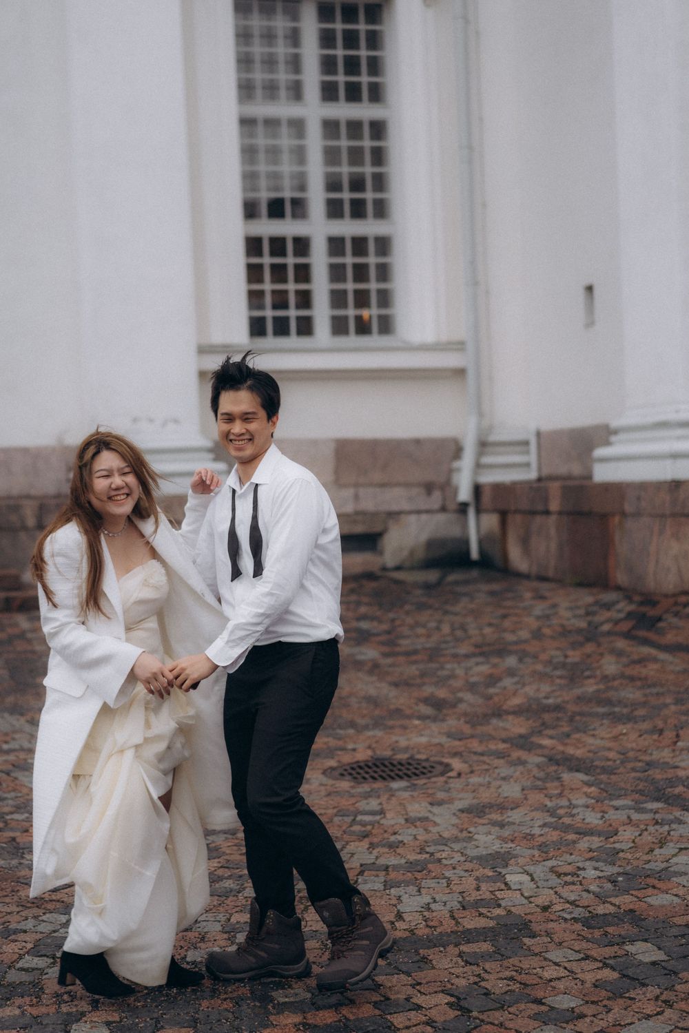 Engaged couple standing together by Helsinki Cathedral during an editorial engagement photoshoot
