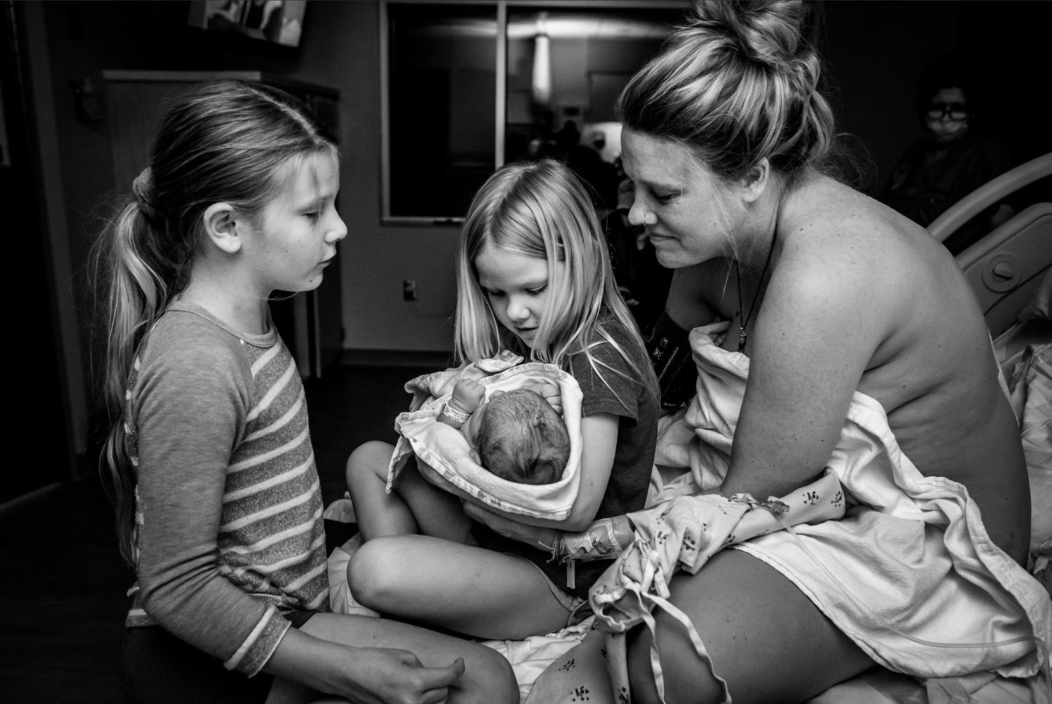 Family members gather around to meet their newest addition in the hospital.