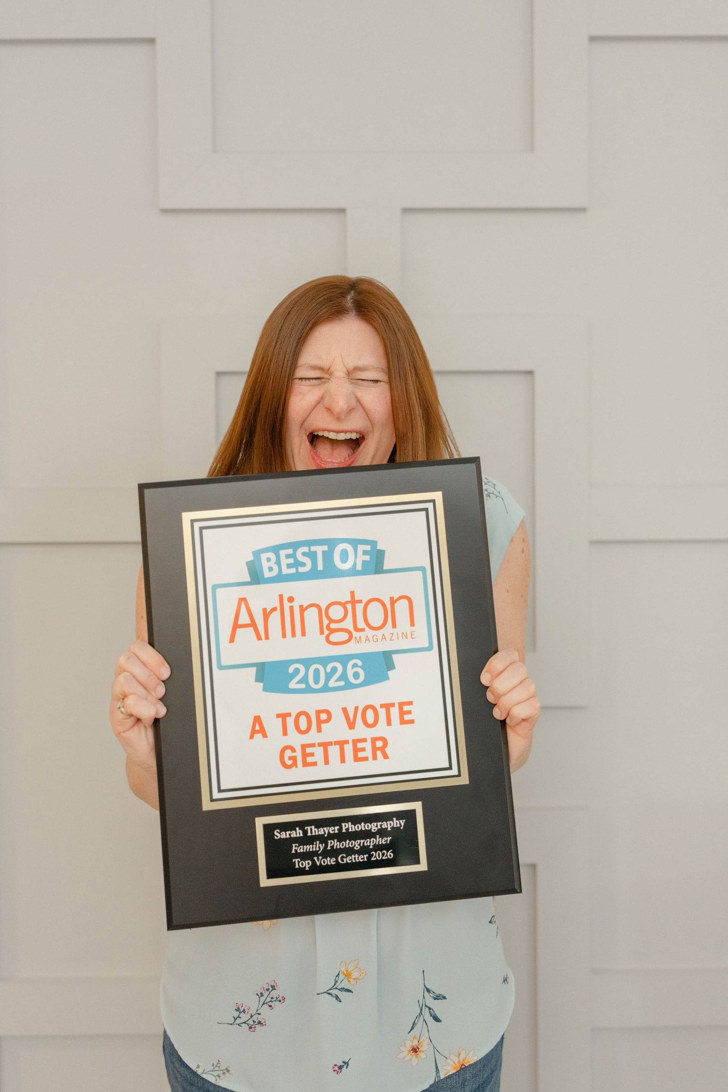 Sarah -- very excited -- holding Best of Arlington 2026 Top Vote Getter award plaque for Sarah Thayer in Family Photography.