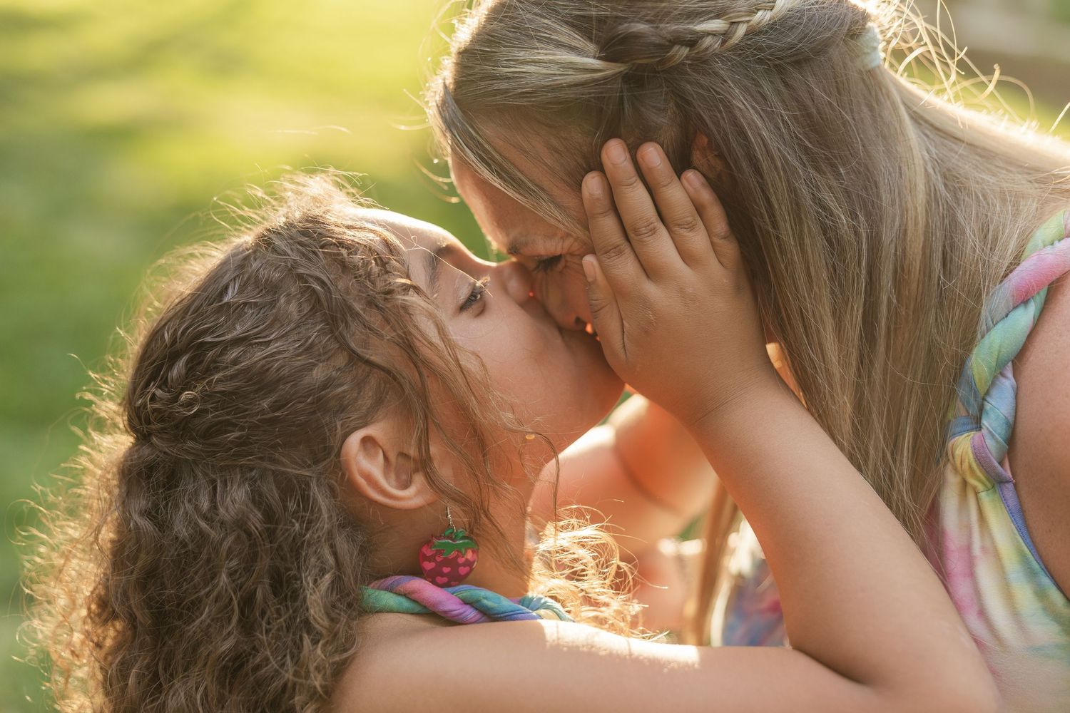 Little girl giving her mom a kiss in Hickory, NC at McComb Park at sunset.