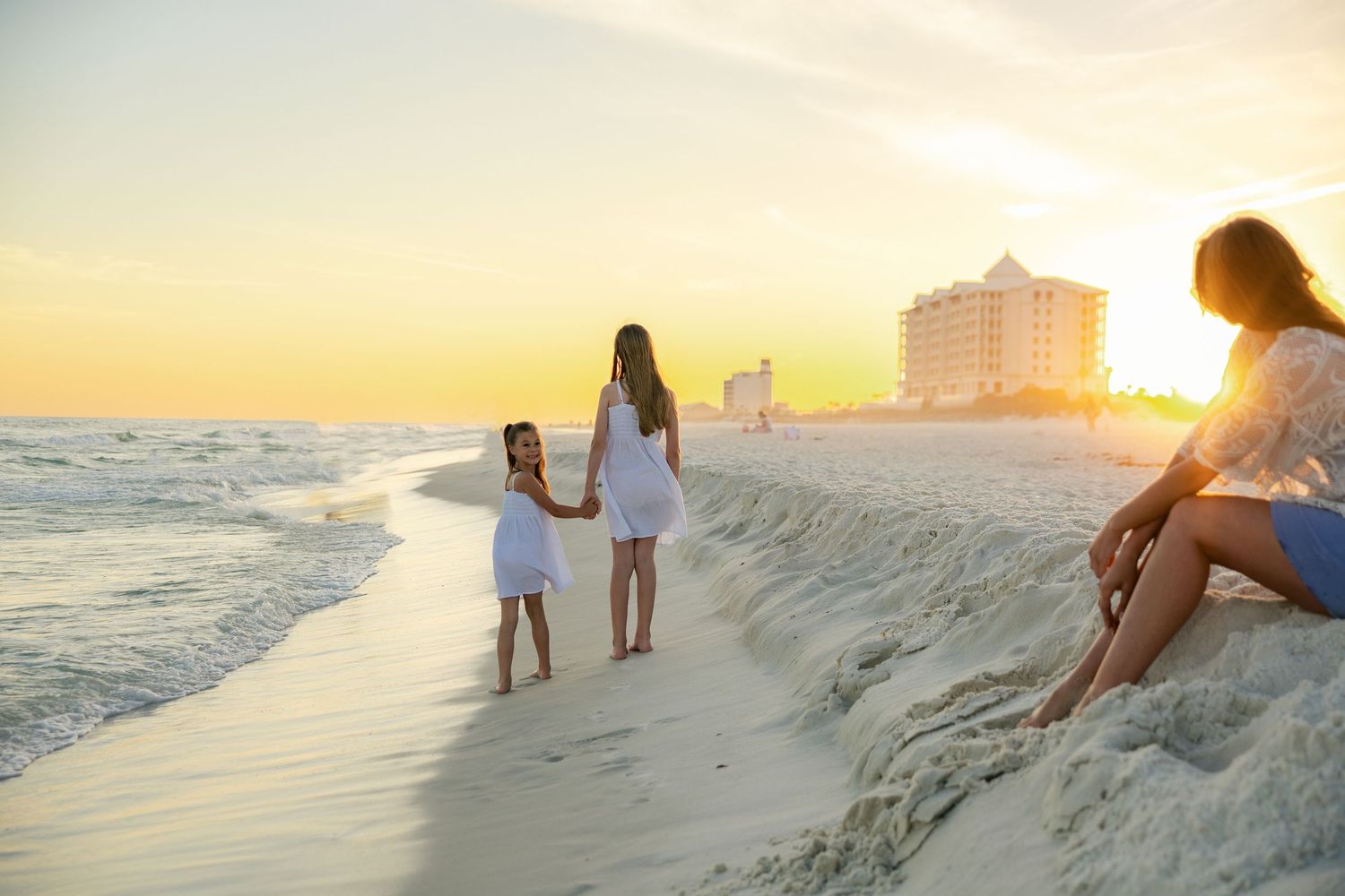 a mother watching her kids play during golden hour on the beach