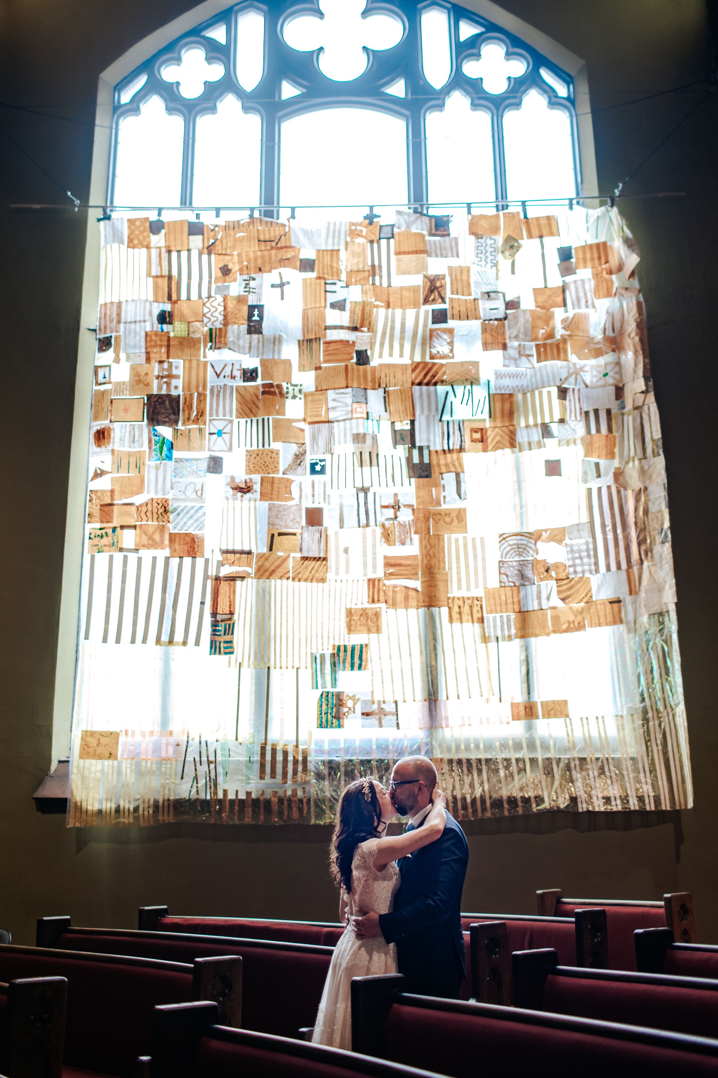 A window display with numerous paper cards and letters hanging from strings creates a unique artistic installation.