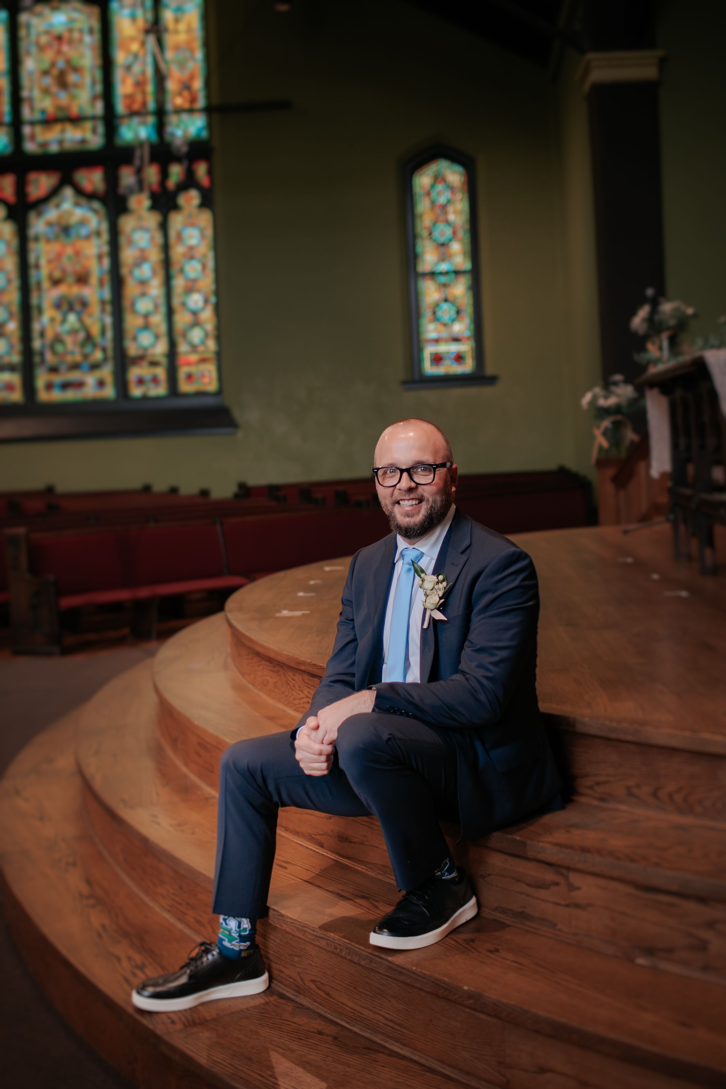 A series of photos showing someone sitting on curved wooden church pews with stained glass windows visible in the background.