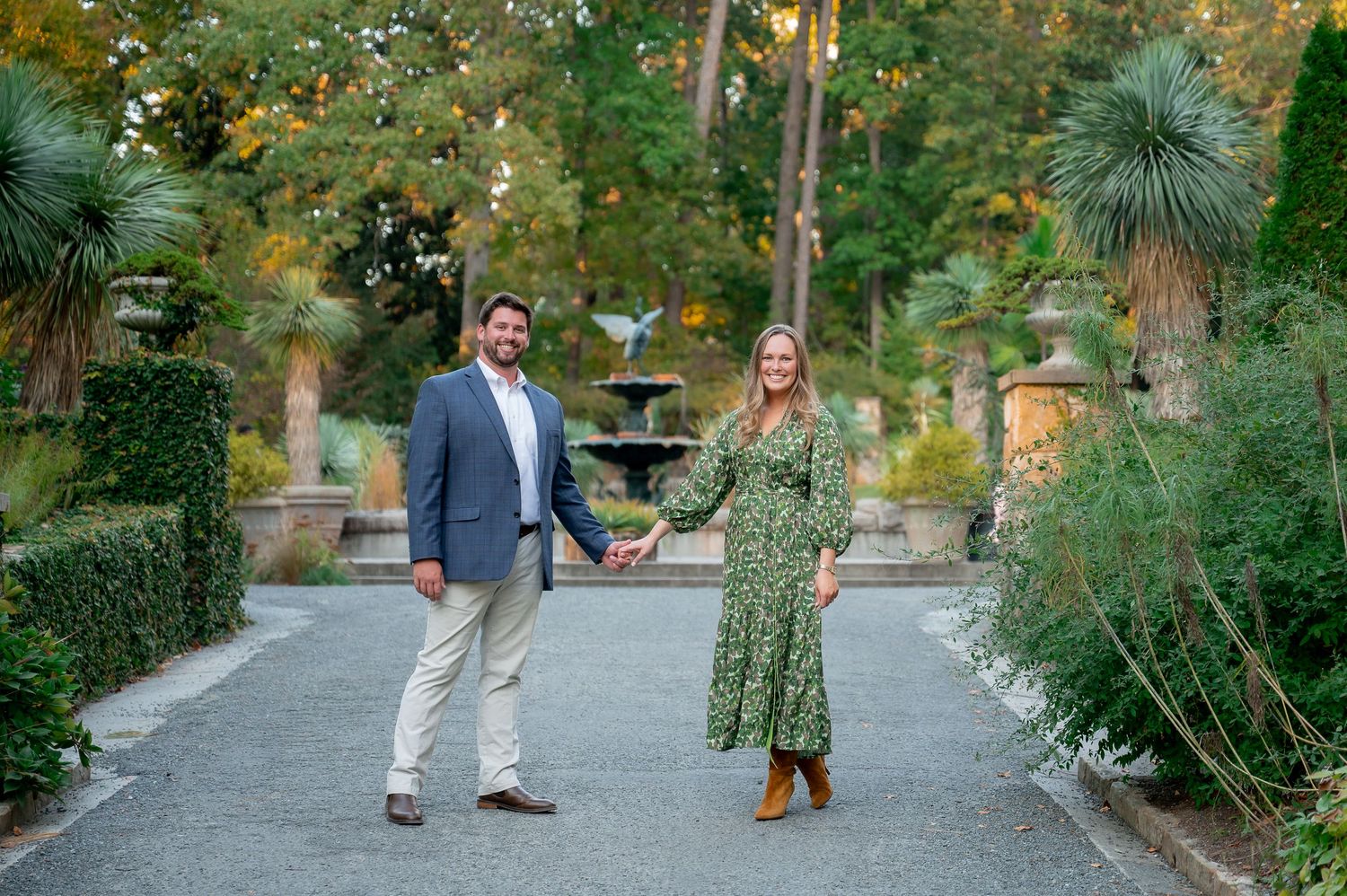 A couple walking together on a gravel path in a lush garden setting during autumn.