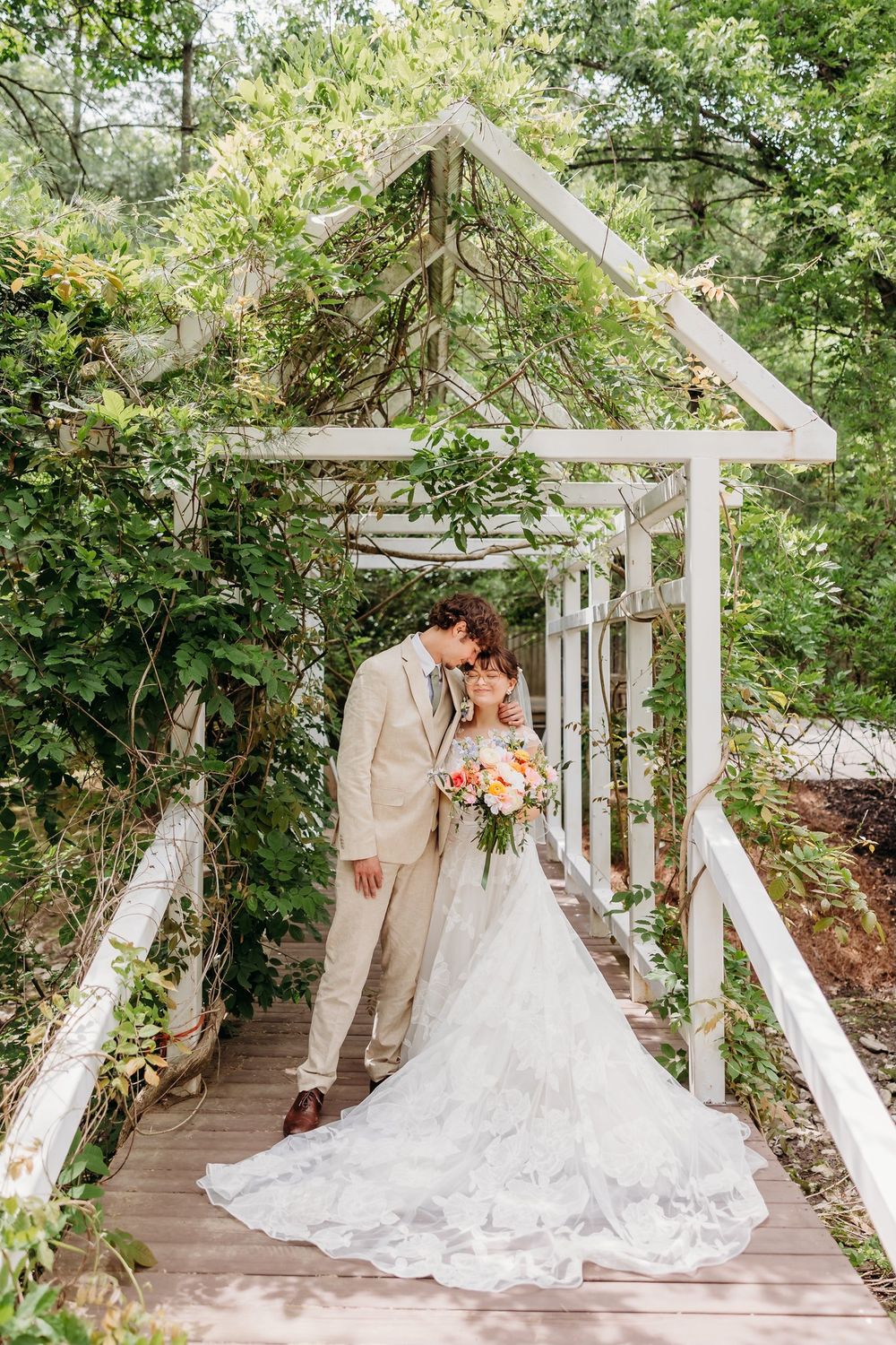 Bride and groom posing under a beautiful garden bridge at their wedding at The Inn at Oneonta in Northern Kentucky.