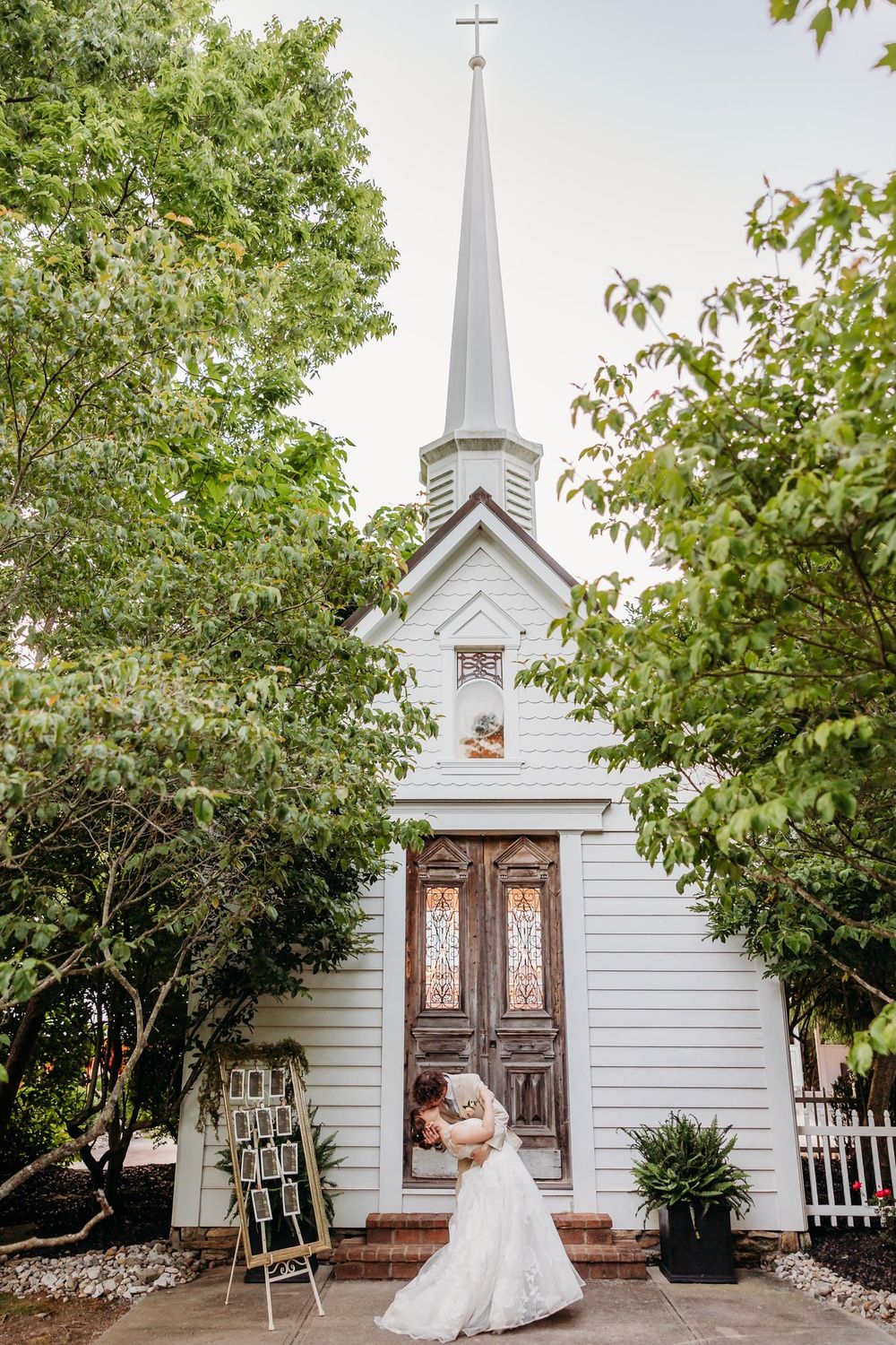 Bride and groom doing a dip kiss in front of a chapel at The Inn at Oneonta in Northern Kentucky.