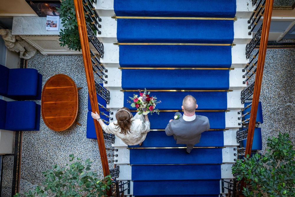 Bride and her son walking up a blue staircase at Southport Town Hall wedding, candid North West documentary moment