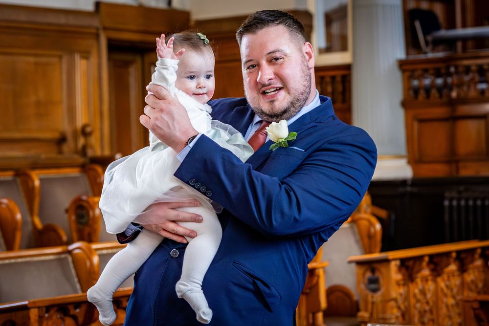 Father holding baby during ceremony at Southport Town Hall wedding in Merseyside, natural family moment