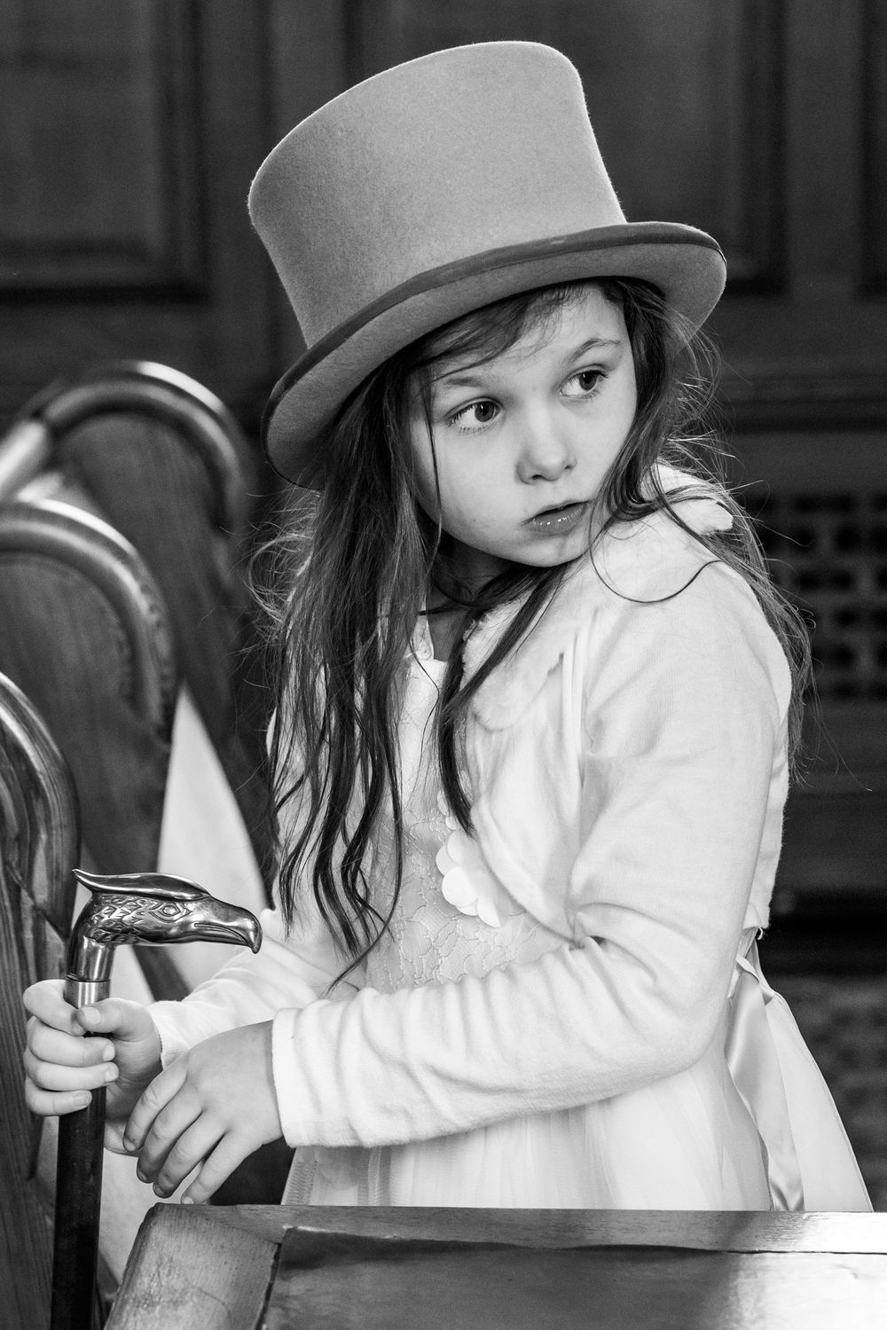 Flower girl wearing grey top hat at Southport Town Hall wedding in Lancashire, relaxed documentary photography