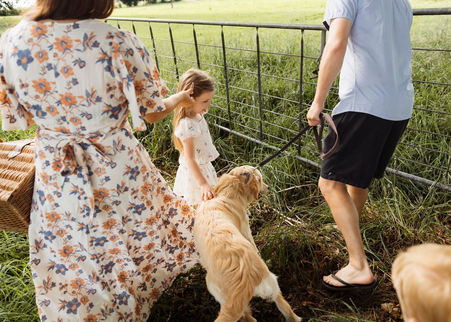 lady, man, little girl and dog going through a gate