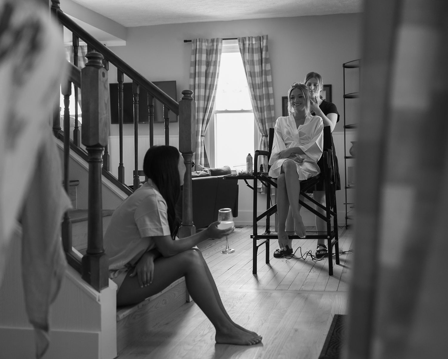 A bride and her bridesmaid share a moment amongst mimosas and getting ready