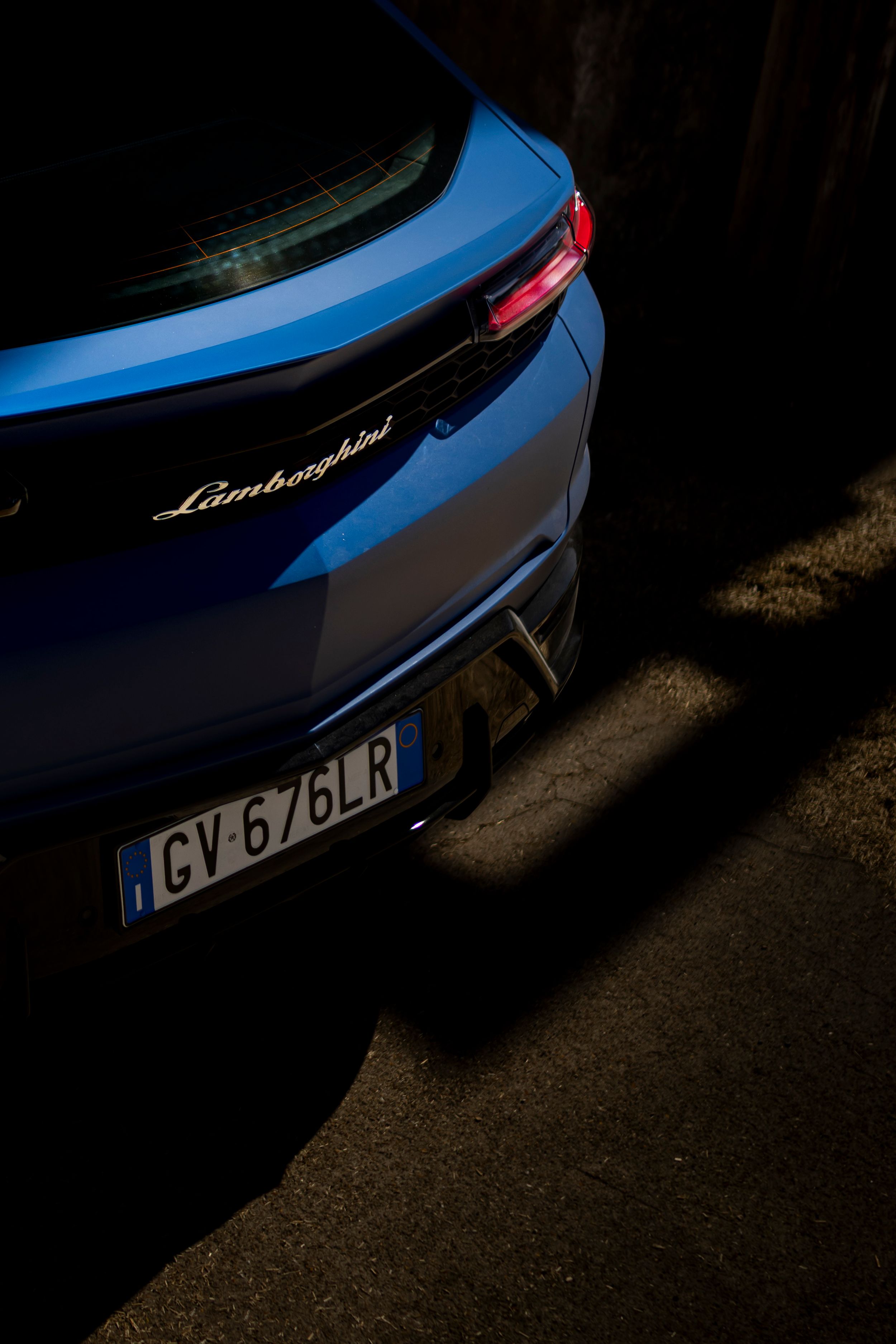 Gros plan artistique arrière Lamborghini bleue lumière et ombres
