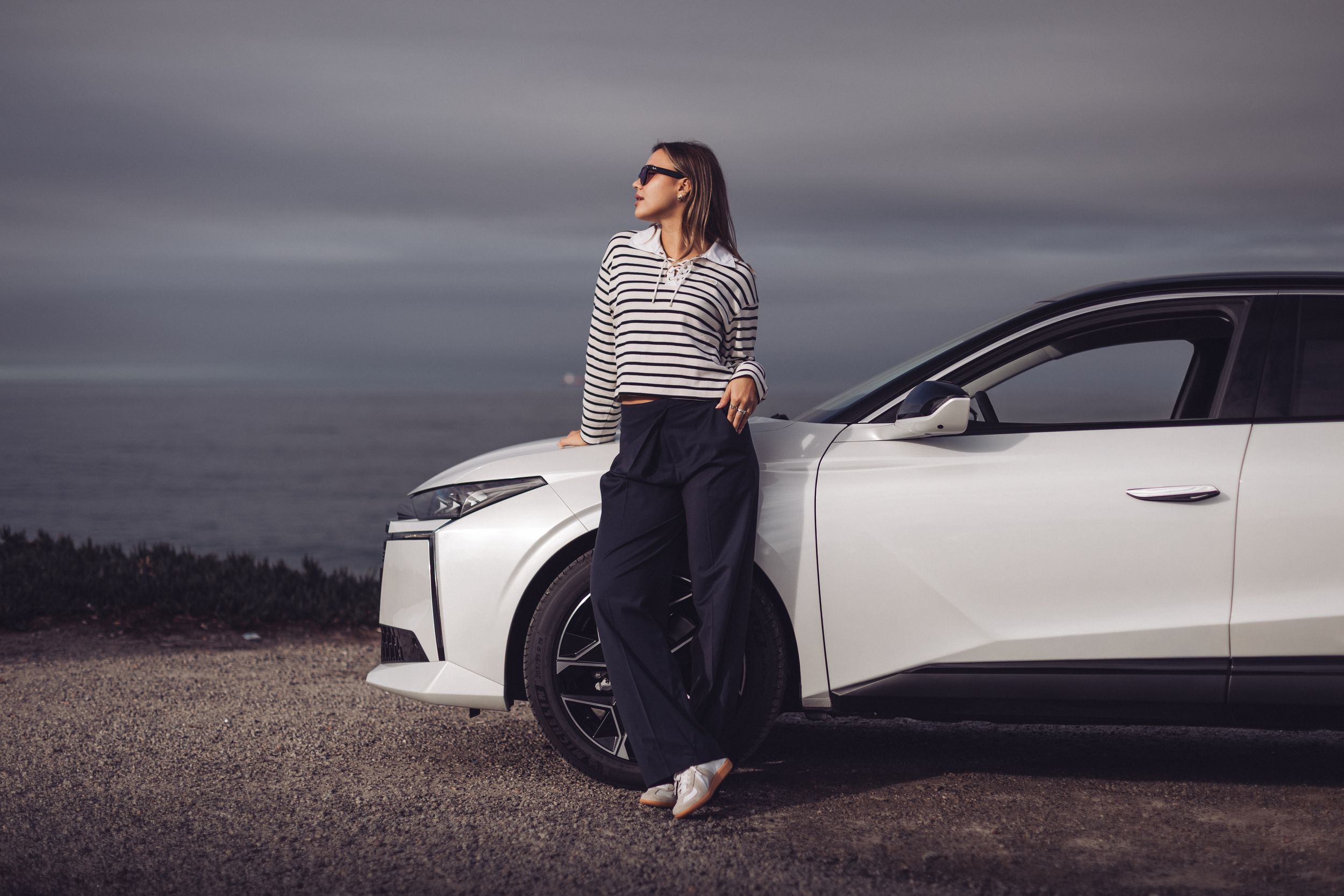 Photographie lifestyle automobile femme avec voiture blanche vue océan