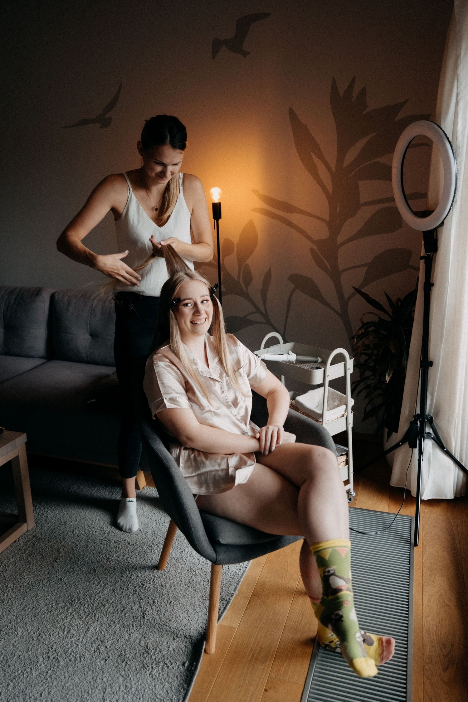 Series of intimate photos showing someone putting on compression socks while sitting on a couch in a dimly lit room.