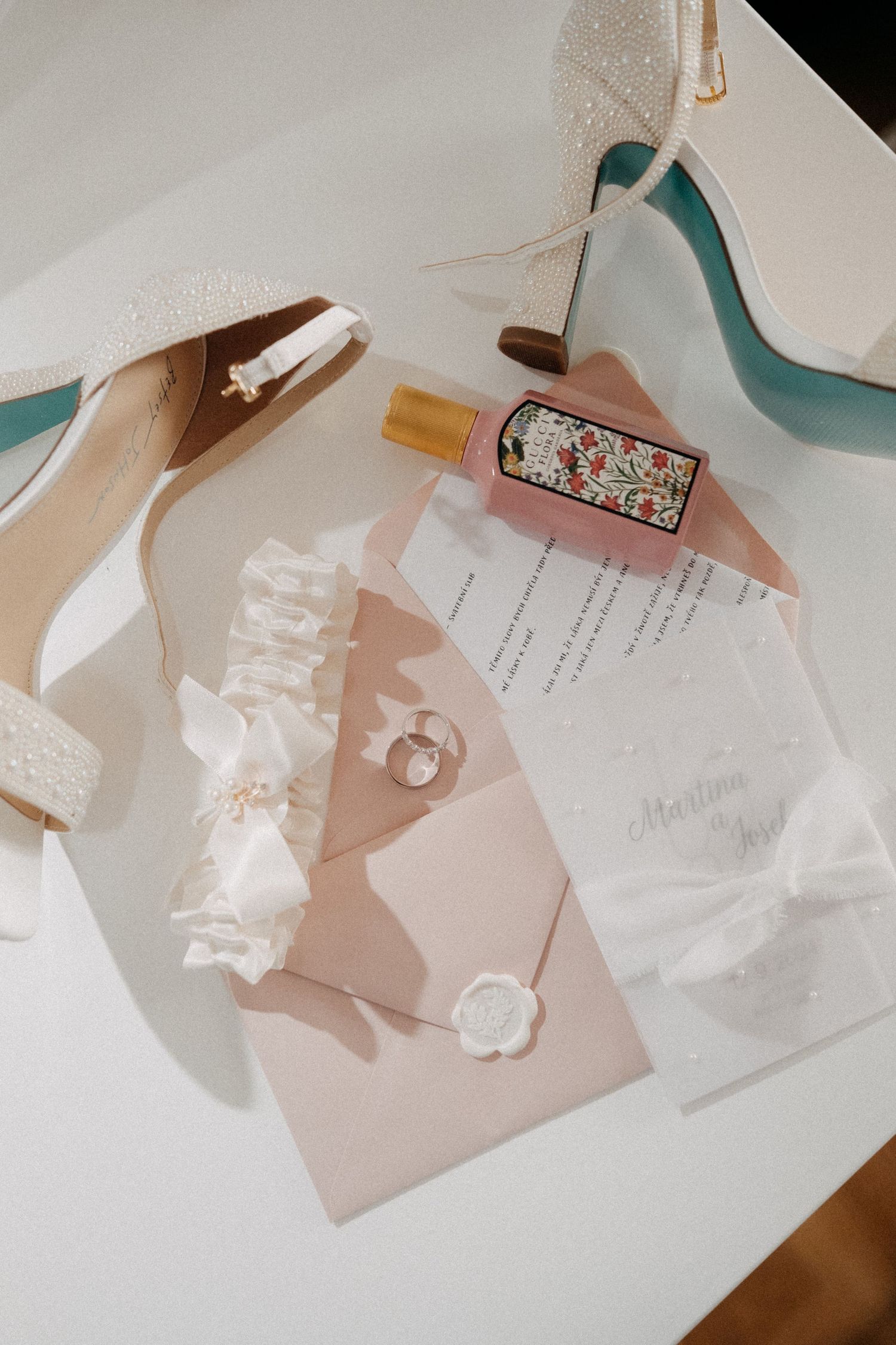 Wedding stationery and invitation details laid out on a white surface with soft pink and neutral tones.