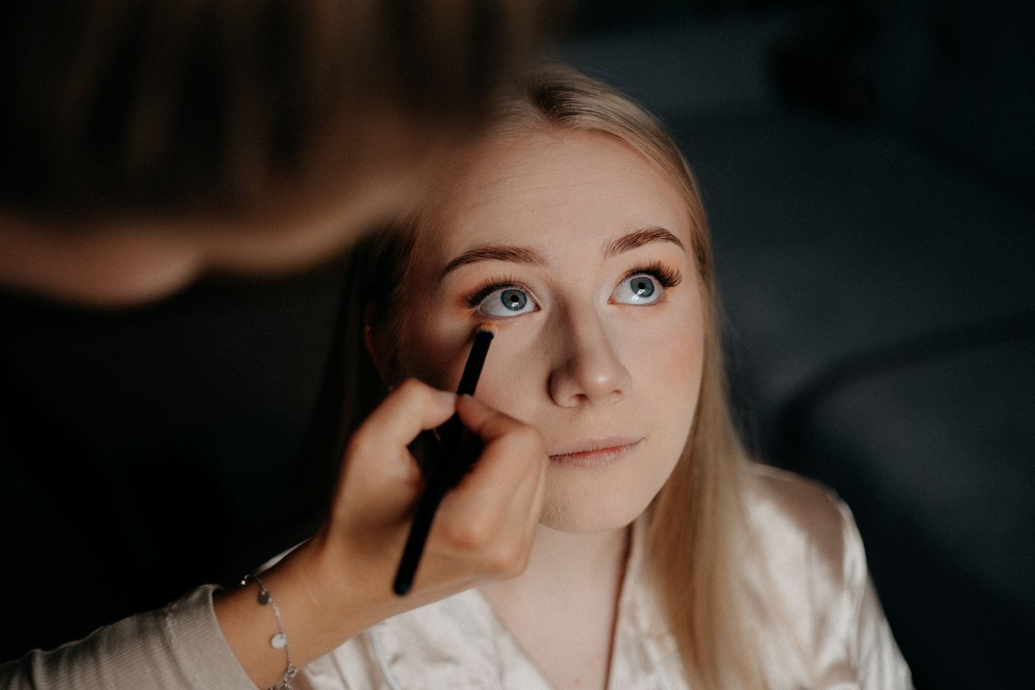 Close-up shot of bridal makeup preparation with soft lighting and neutral tones.