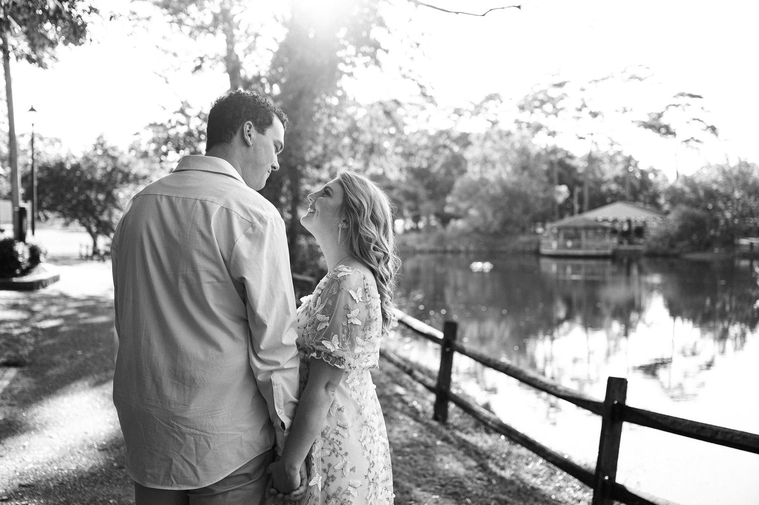 A couple poses together on a stone bridge in a romantic outdoor setting.